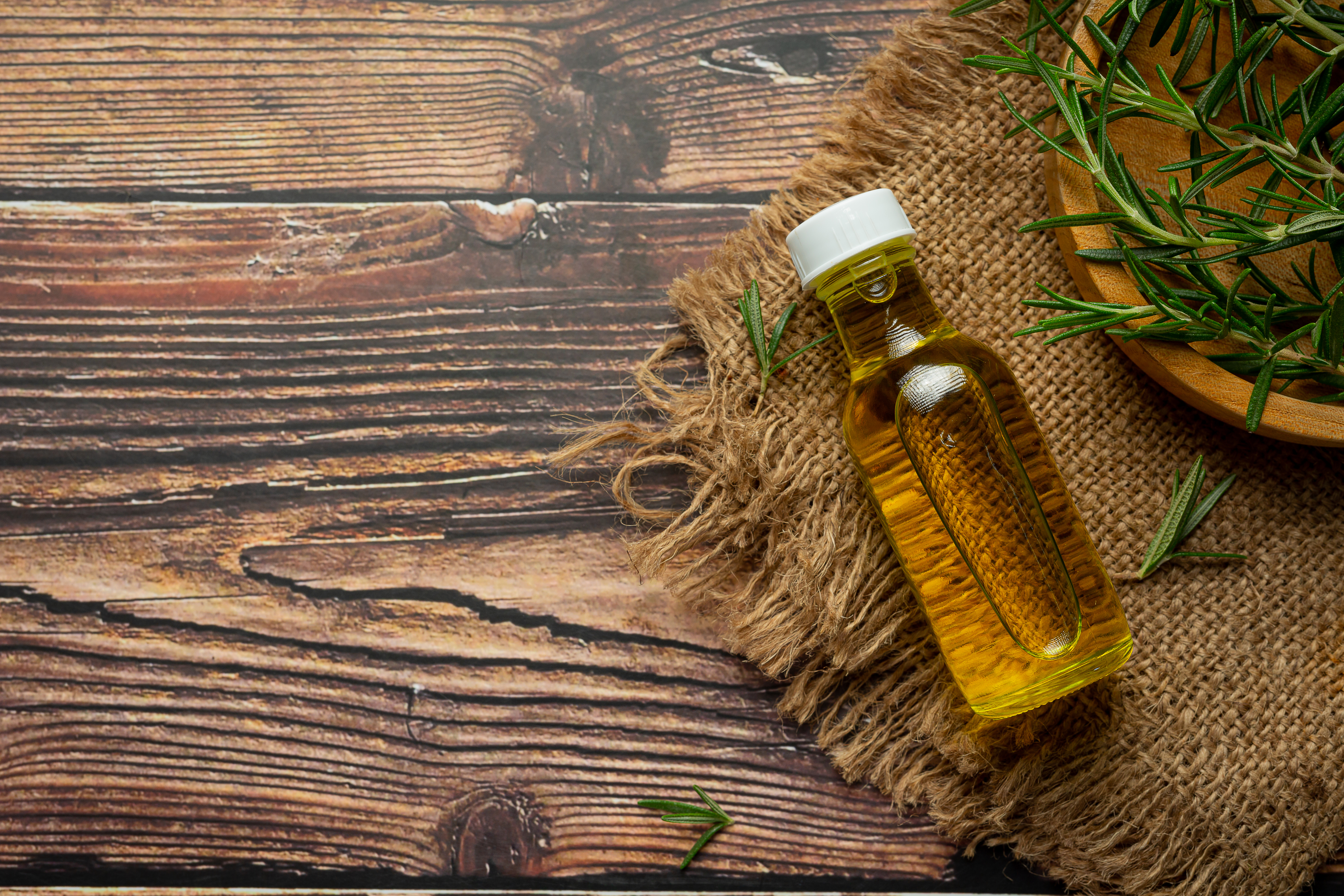 Rosemary oil in bottle with rosemary plants